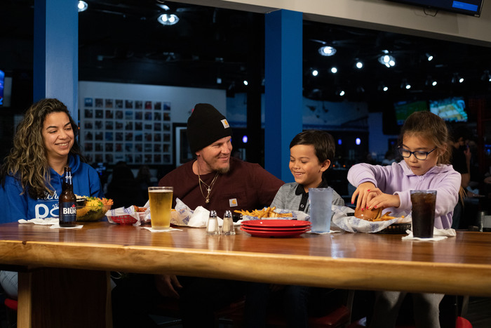 A family sharing burgers and wings at a table at The Dirty Buffalo
