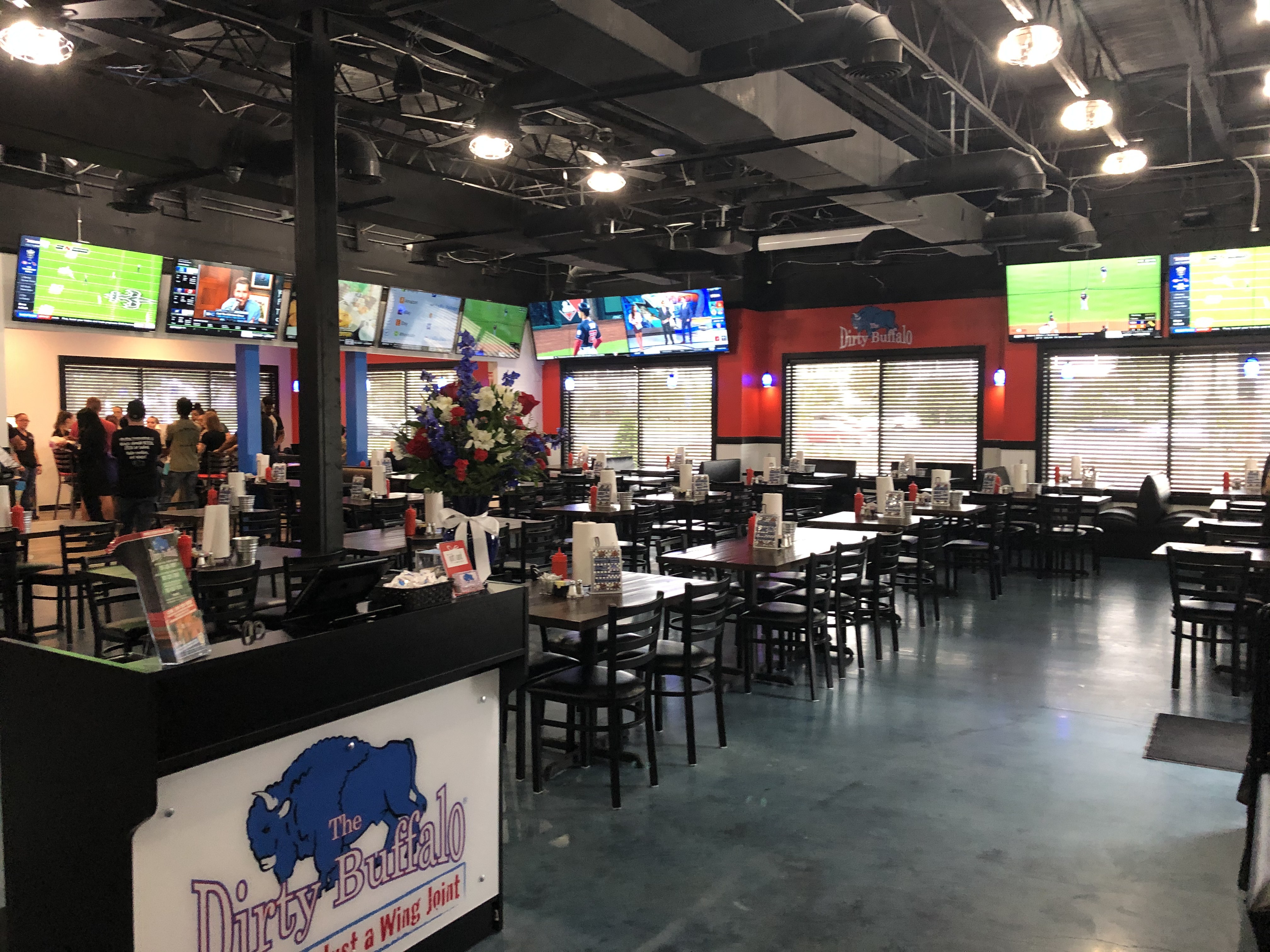The dining room at The Dirty Buffalo Princess Anne with booths, tables and TVs overhead
