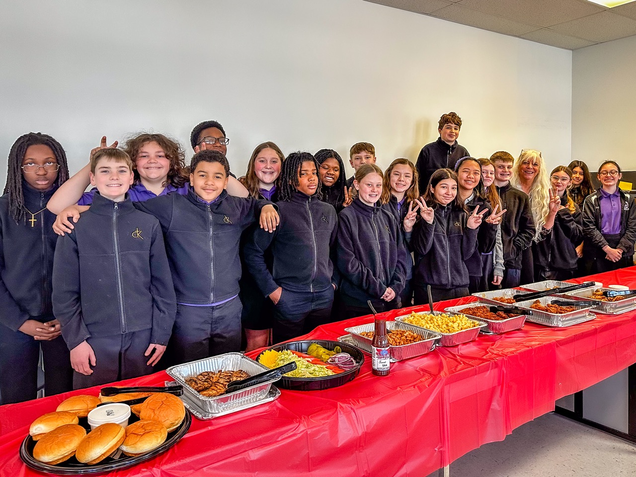 Students gathered around a Dirty Buffalo catering table at a school event