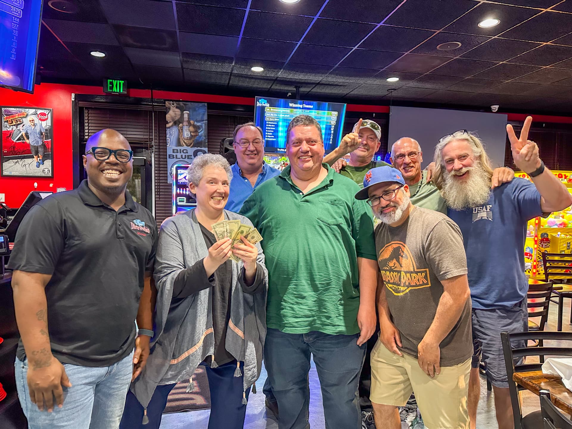 A winning trivia team holding their cash prize at The Dirty Buffalo