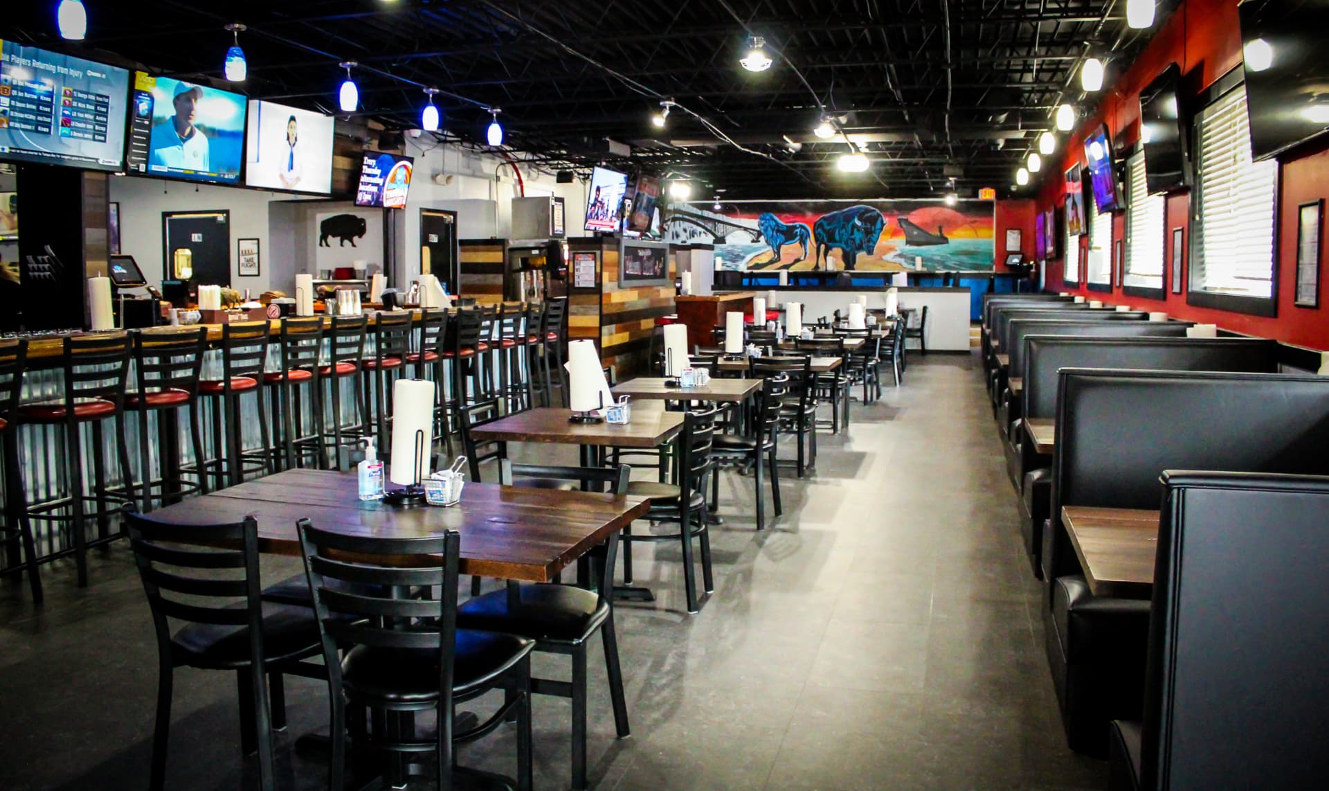 Inside The Dirty Buffalo Colley Ave — booths, bar seating, TVs and the painted buffalo mural