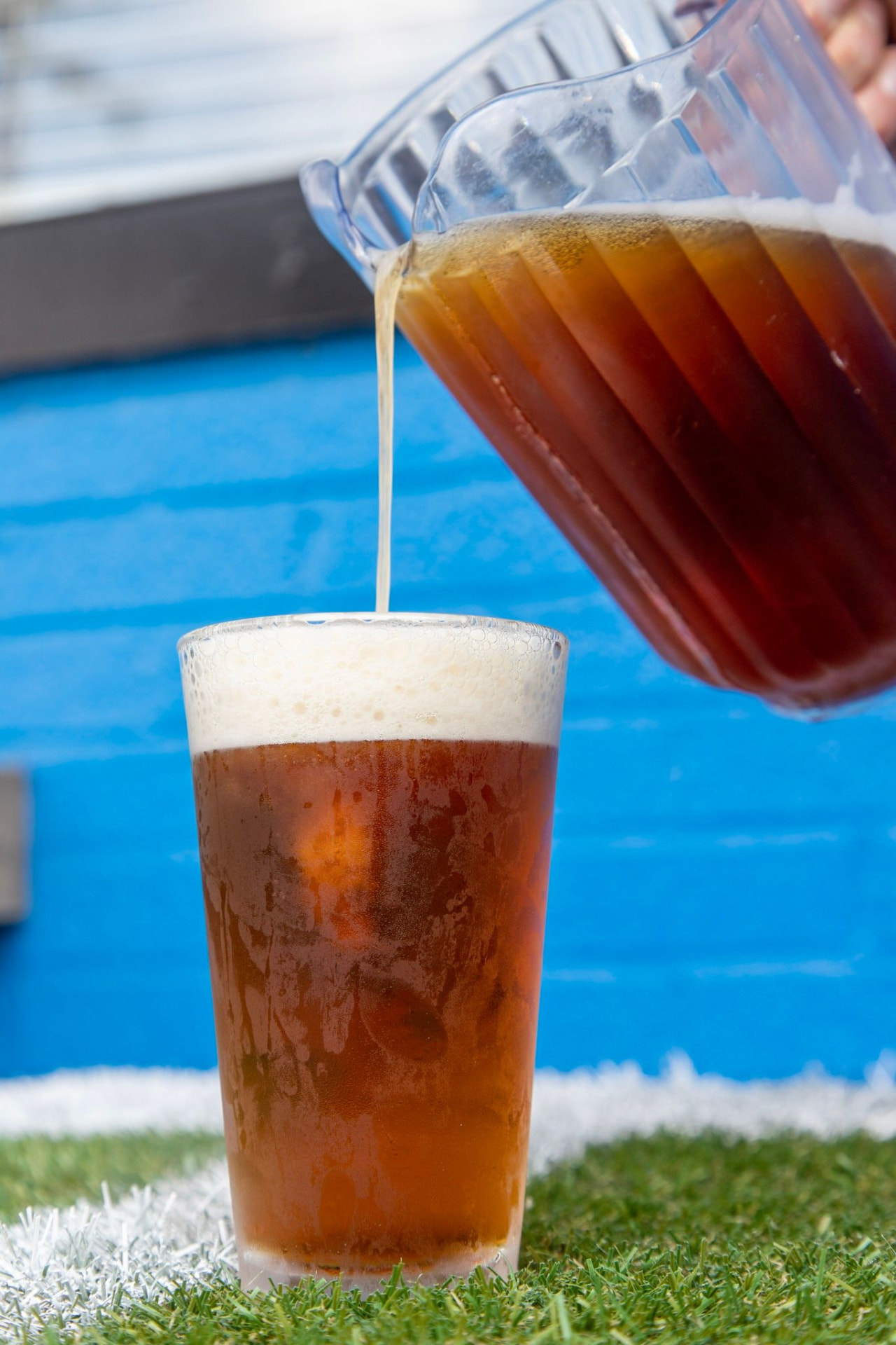A pitcher of cold beer being poured into a cup at The Dirty Buffalo