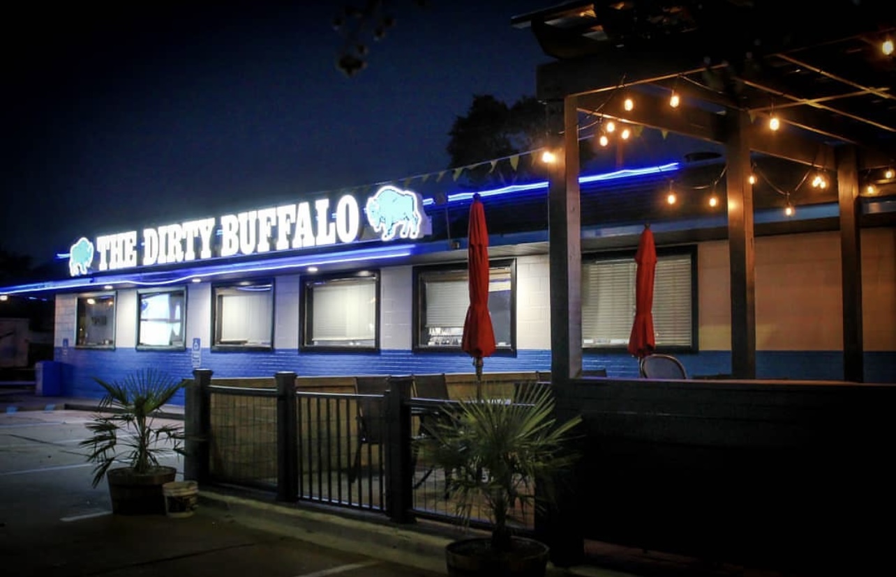 The Dirty Buffalo on Colley Ave in Norfolk at night, neon sign lit up over the string-lit patio