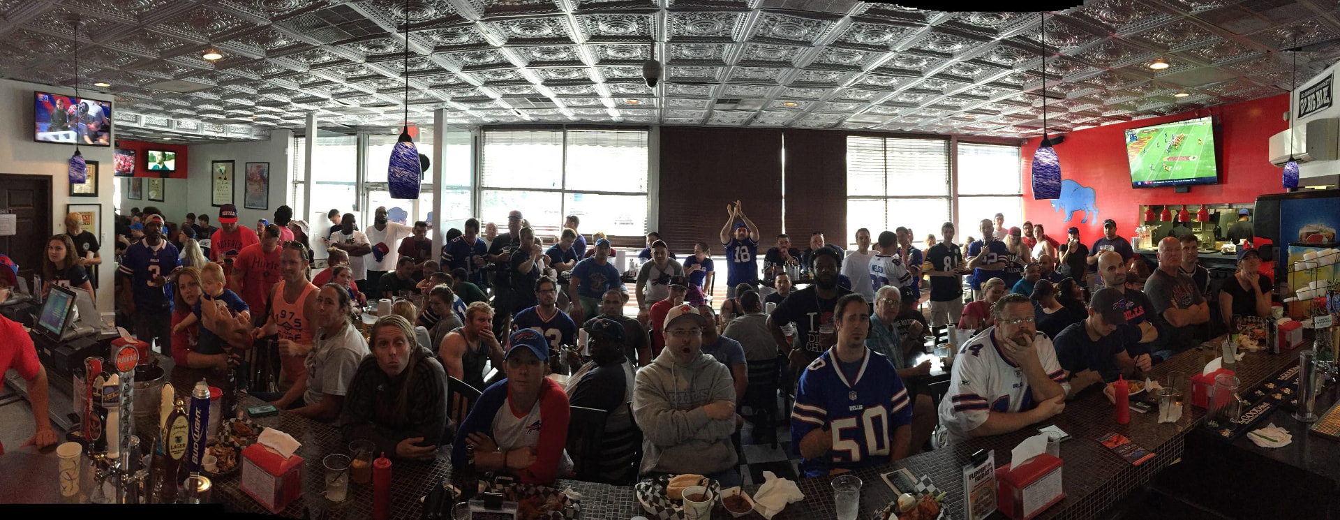 A packed original Dirty Buffalo dining room full of Bills fans watching the game