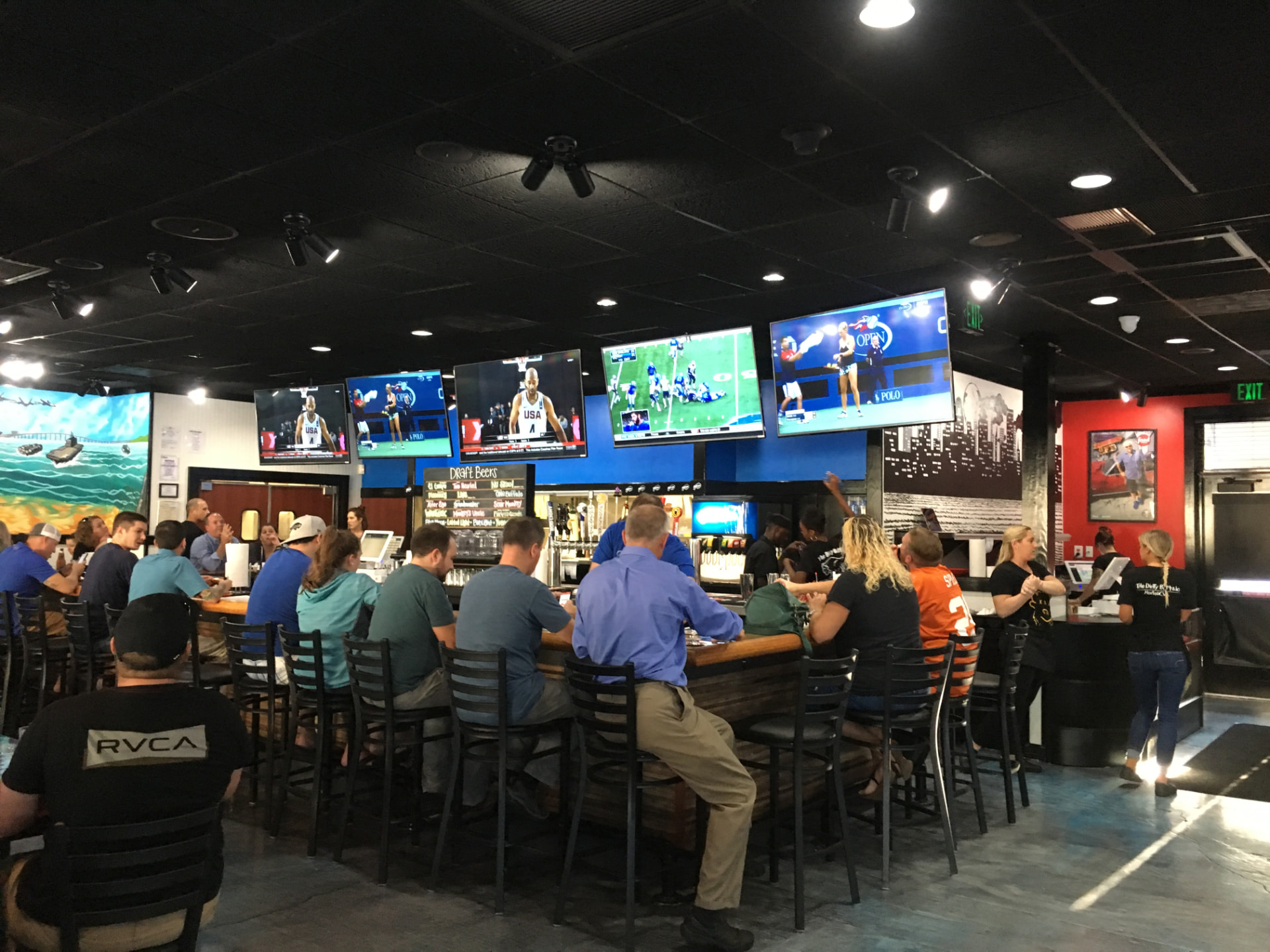 A packed bar at The Dirty Buffalo Little Creek in East Beach with TVs showing games overhead