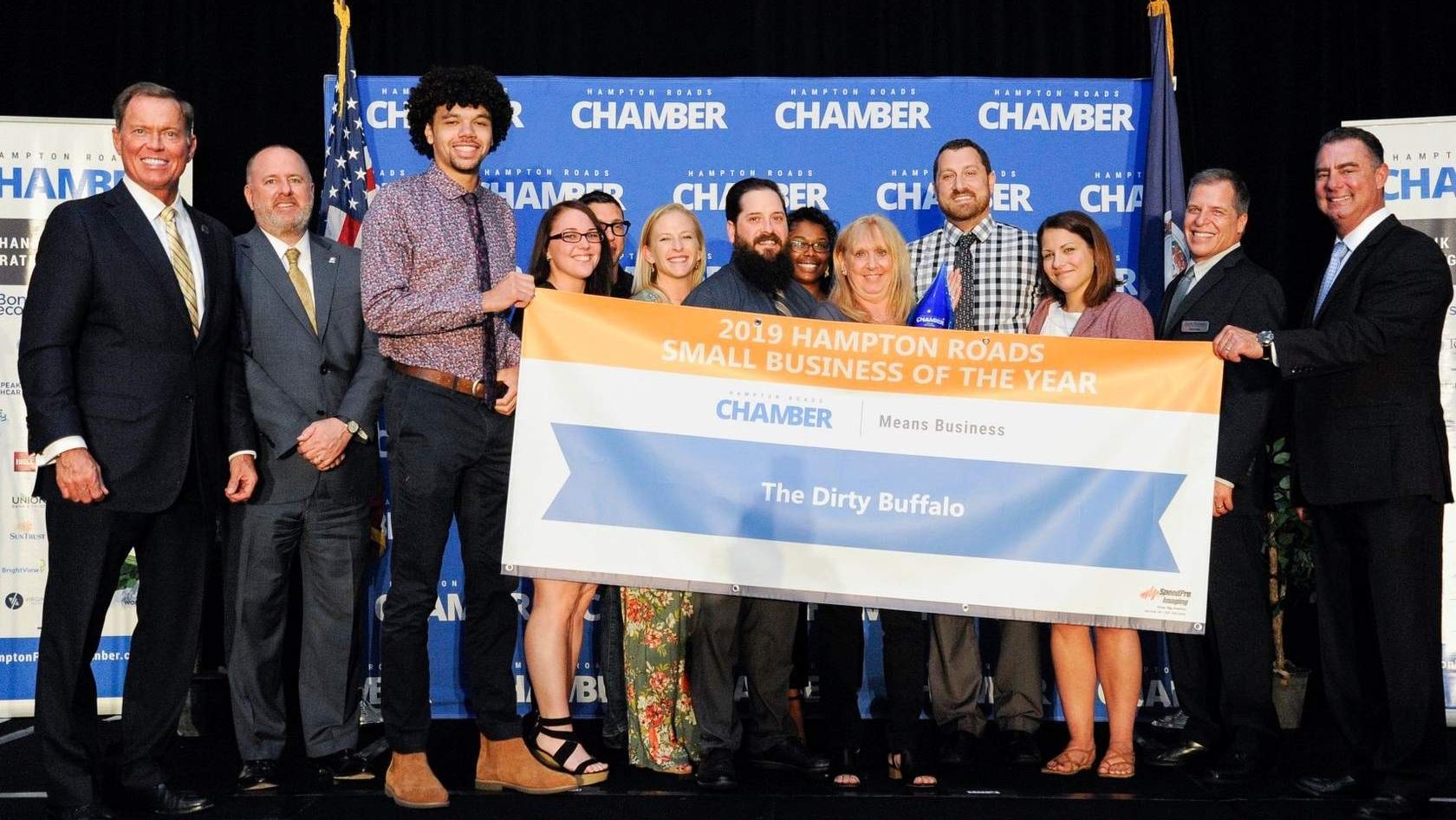 The Dirty Buffalo team on stage holding the 2019 Hampton Roads Small Business of the Year banner