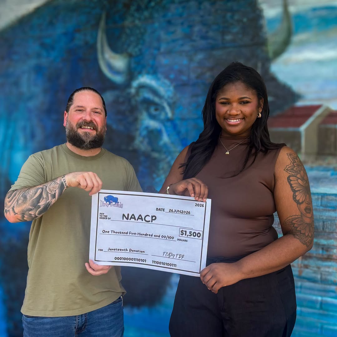 TDB presenting a Juneteenth donation check to the NAACP in front of the blue buffalo mural