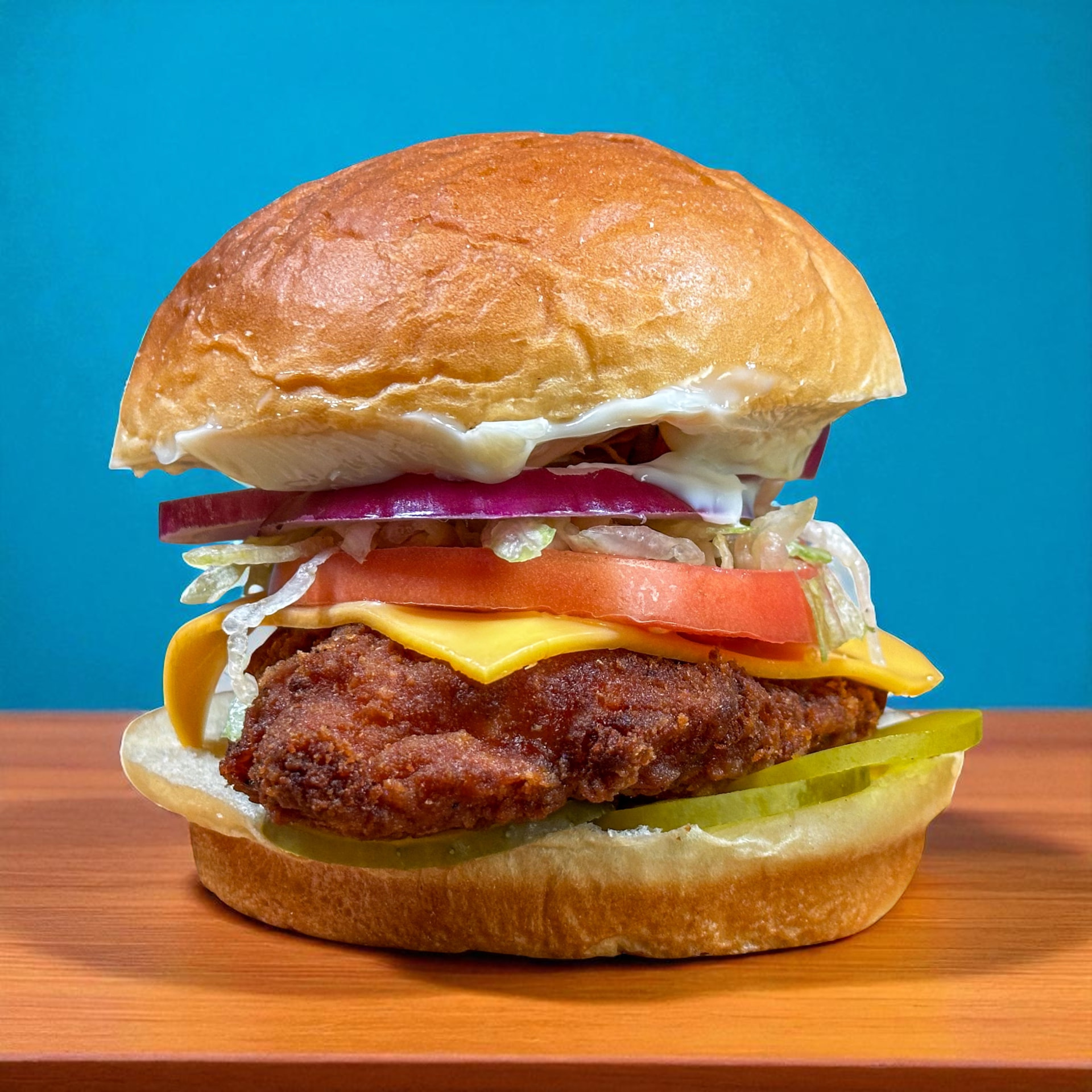 Crispy chicken sandwich with American cheese, lettuce, tomato and pickles
