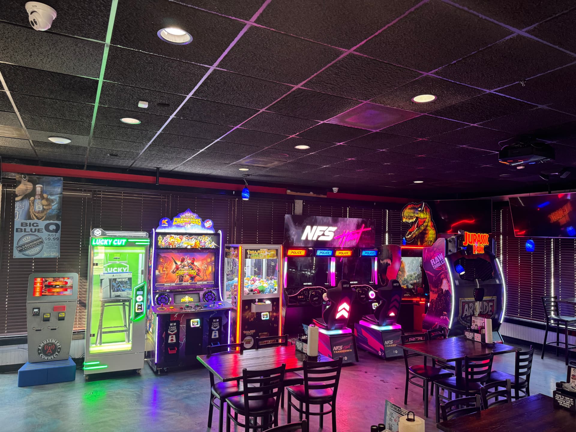 The game room at The Dirty Buffalo Little Creek — NFS Heat racing, Jurassic Park arcade, claw machines and neon lights