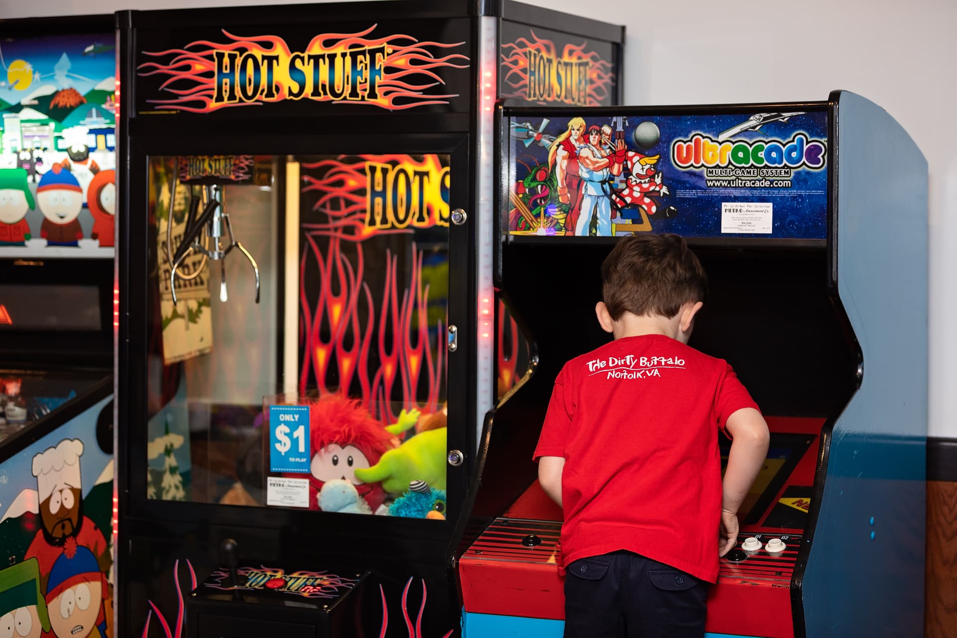 Kids playing arcade games in the game room at The Dirty Buffalo