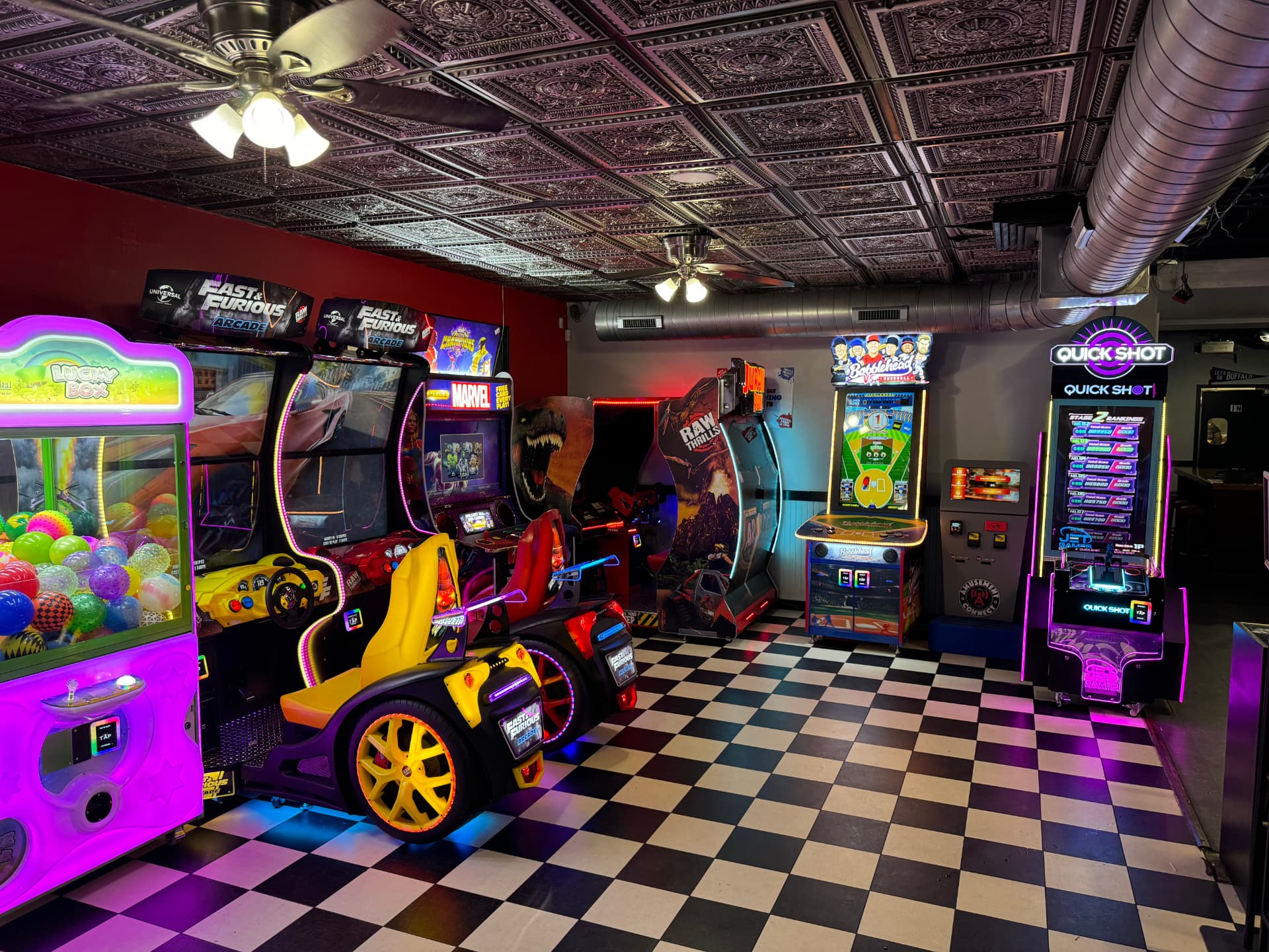 The game room at The Dirty Buffalo Colley Ave — claw machine, Fast & Furious racing, pinball, Quick Shot and other arcade games
